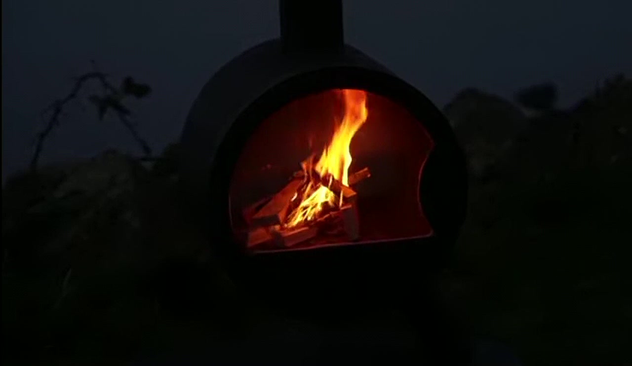 Brandend houtvuur achter het ronde venster van de Larutan